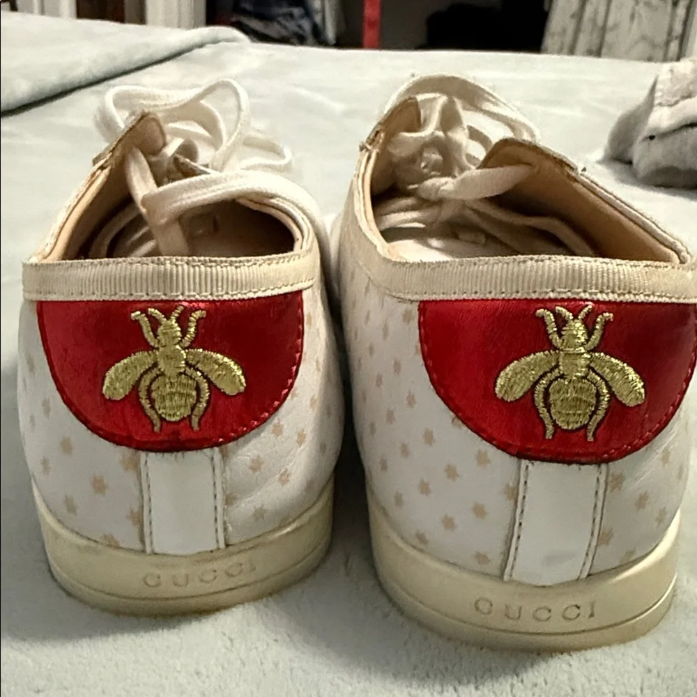 GUCCI Falacer low-top sneaker in white leatherprint in gold and star detailing.
